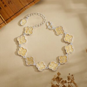 Hand-crafted silver and gold filigree clover bracelet on a Malachite slab for 2026 prosperity ritual.