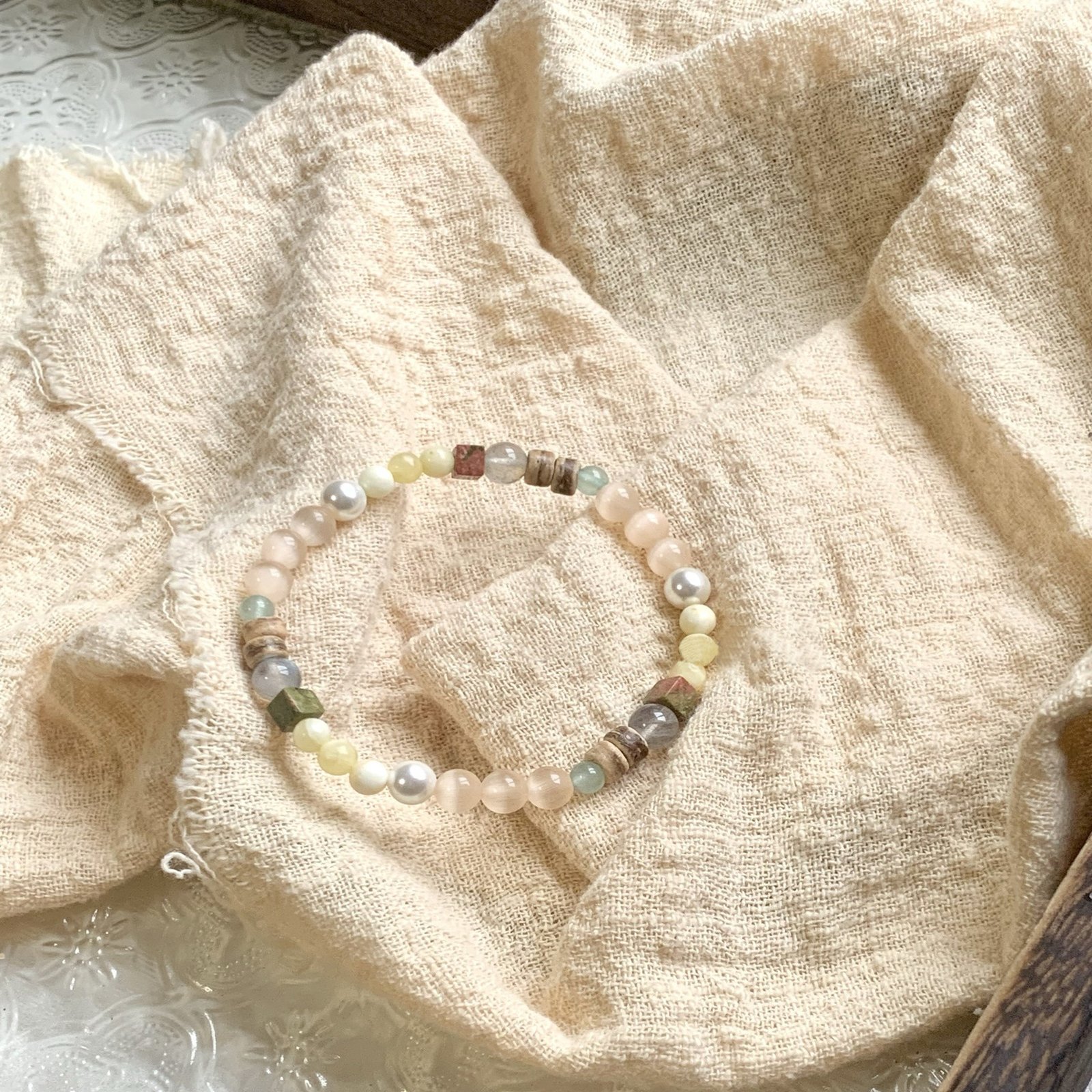 "The Visionary’s Path" – Natural Cat’s Eye Stone Bracelet with Pearls | Intuition & Protection Talisman 3 Close-up of iridescent cat’s eye beads and natural gemstone accents on beige fabric