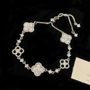 Home 7 Detailed view of silver lucky clover bracelet with white mother of pearl style charms and bolo clasp